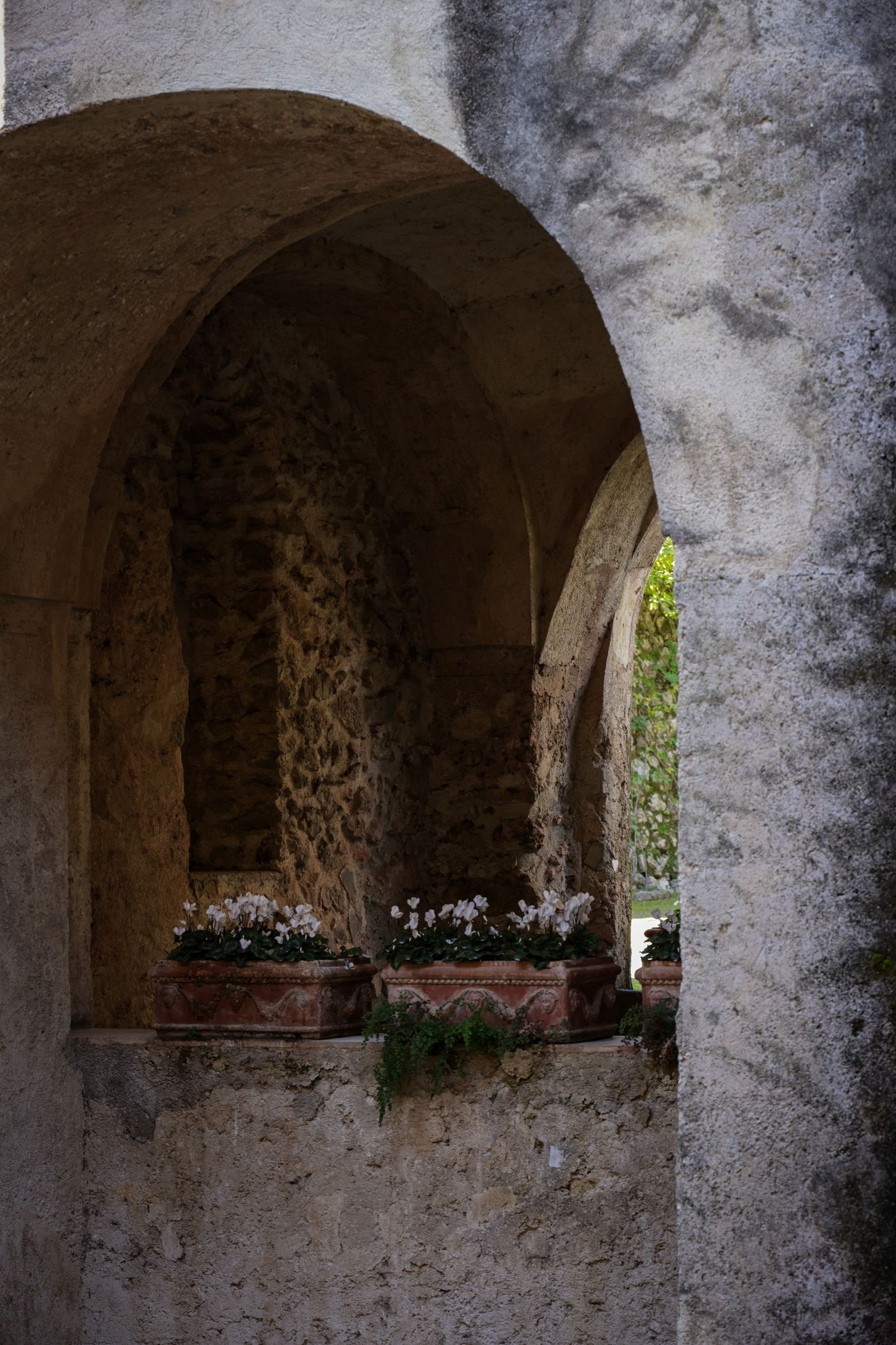 Arco antico in pietra con piccoli vasi di fiori